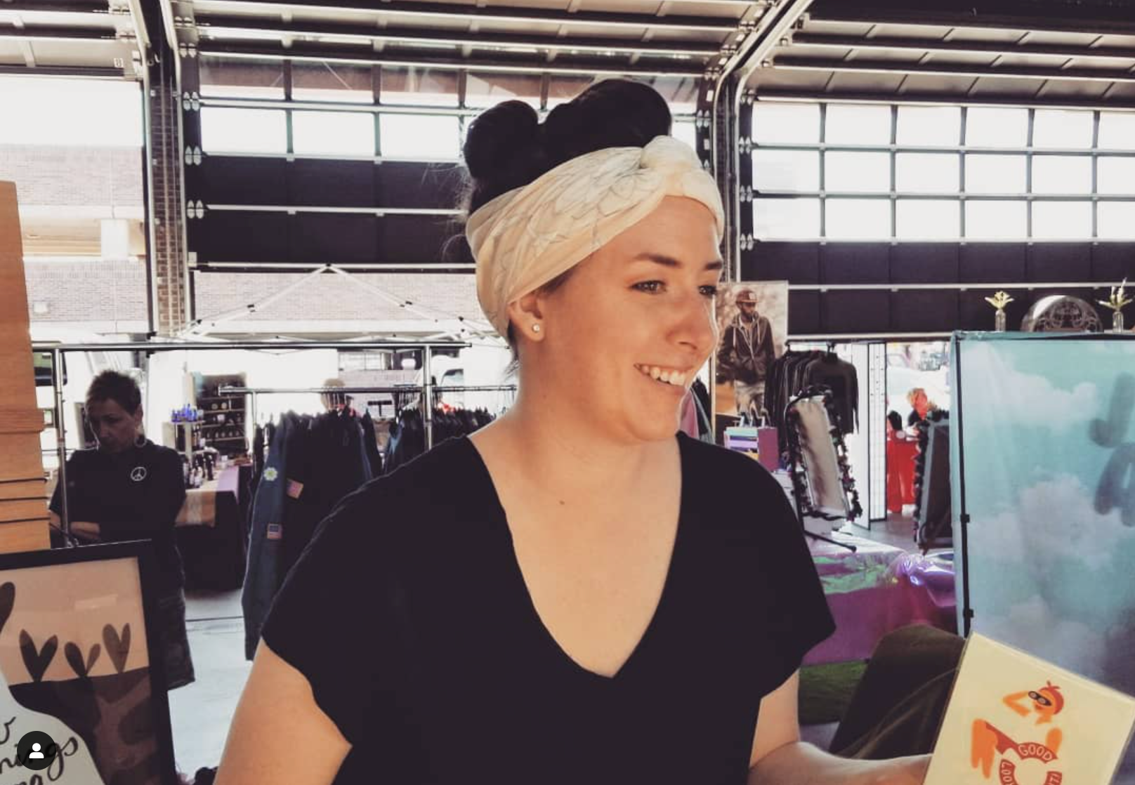 Dote Note + Gift founder Kristen Eakin smiles at a customer while selling greeting cards at shed 5 flea